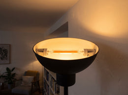 Ampoule LED R7s 118 mm allumée dans la vasque d'un lampadaire, lumière blanc chaud sur le mur et le plafond d'un salon
