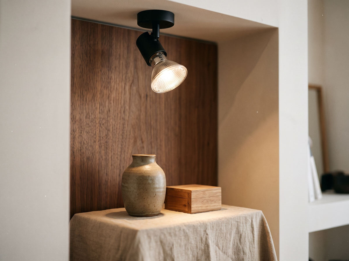 Ampoule halogène PAR20 E27 dans un petit spot noir éclairant un vase en céramique dans une niche de boutique – mise en situation