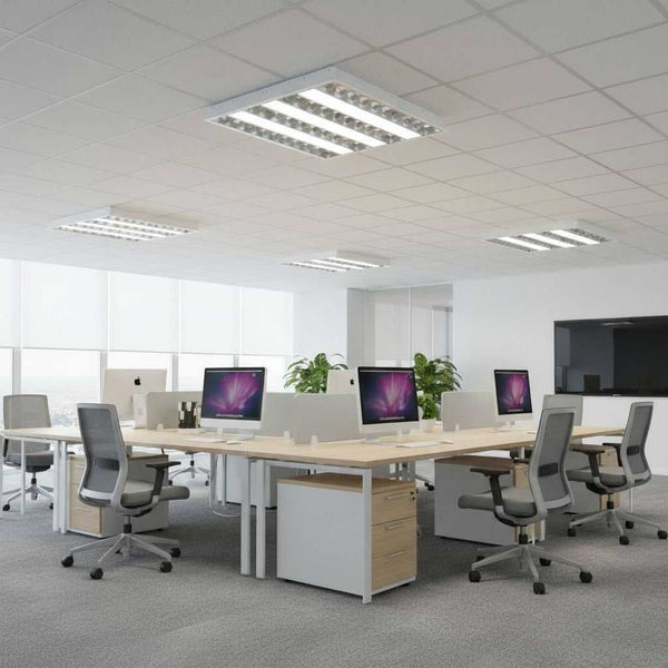 Open space de bureaux éclairé par des plafonniers encastrés à grille, au-dessus des postes de travail